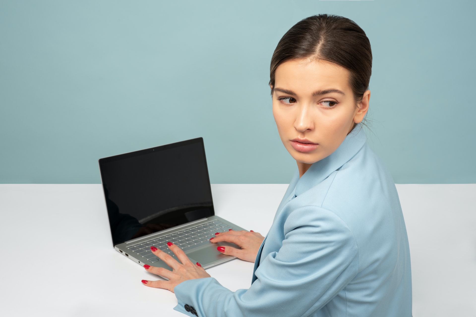 Concerned woman looking away from a laptop