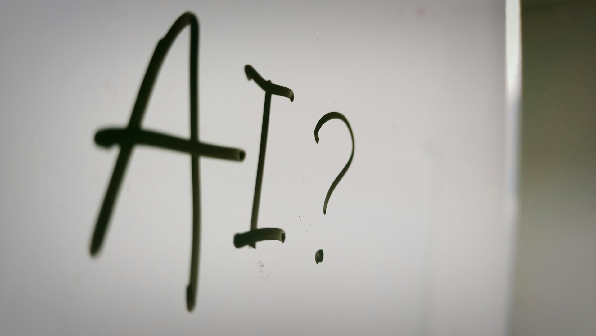 The text "AI?" written on a whiteboard