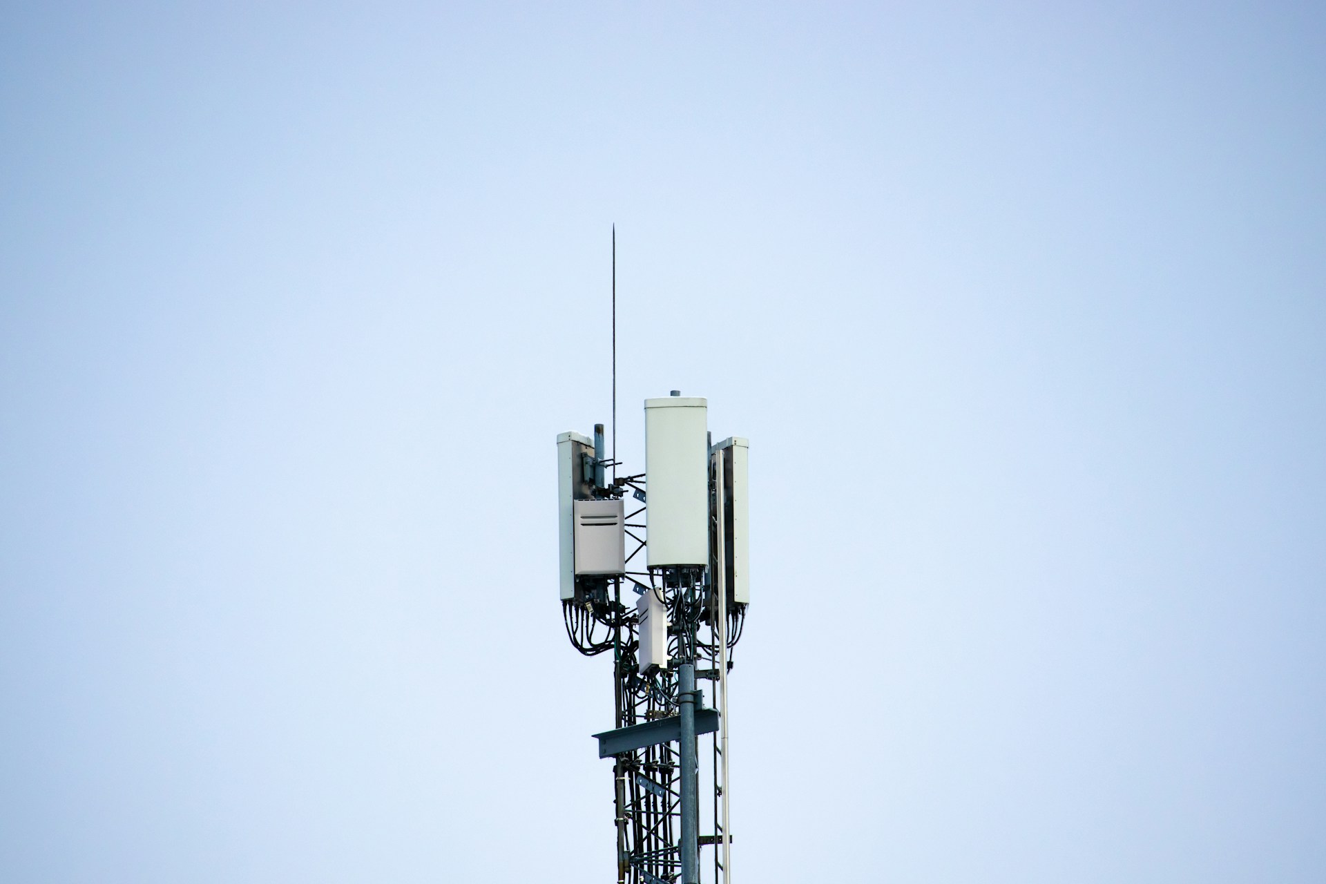 Photo of a cell tower against a bright blue sky