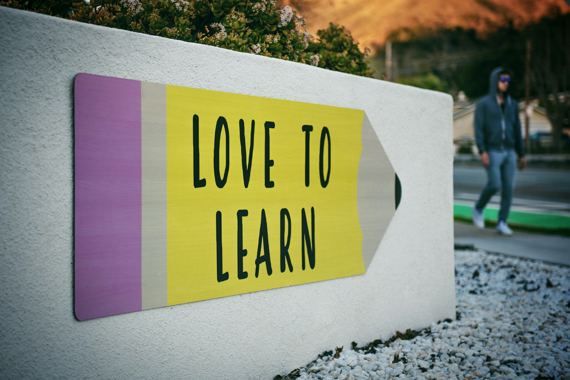 A pencil-shaped sign that reads 'Love to Learn'.